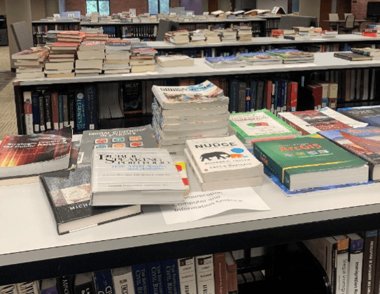 A Free Book Fair where multiple books placed on top of a book shelve, available for everyone to take and read.